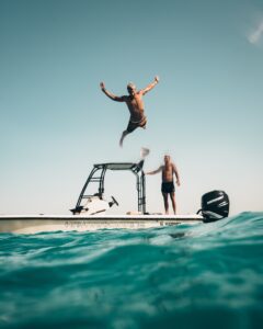 Man jumping off boat in to water