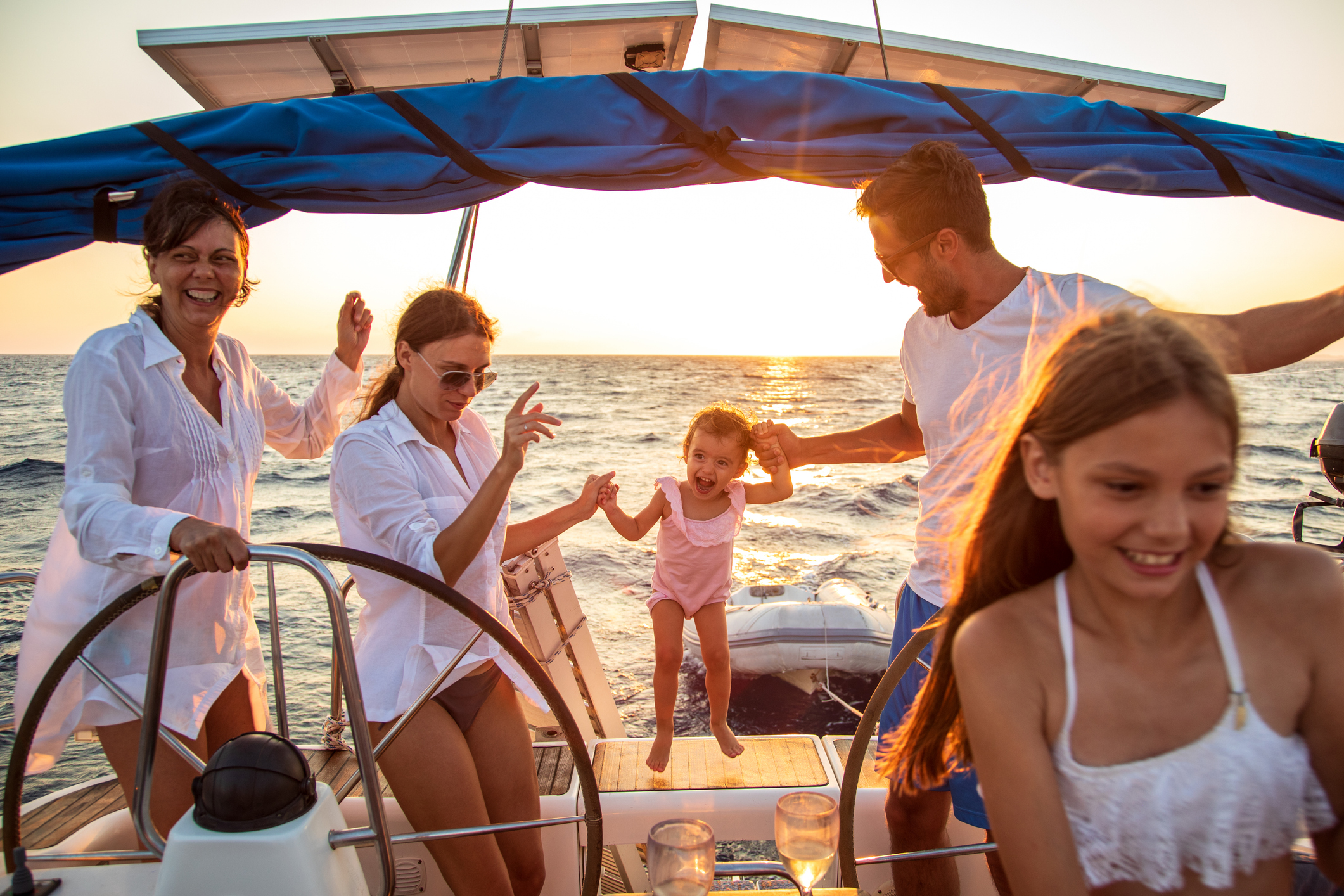 Family dancing on a yacht at sunset