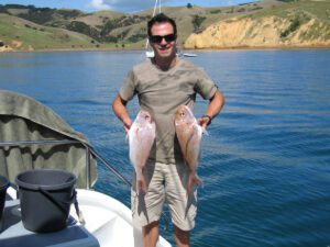 Man holding 2 freshly caught Snapper 